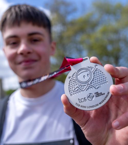 Mini marathon boy holding a medal