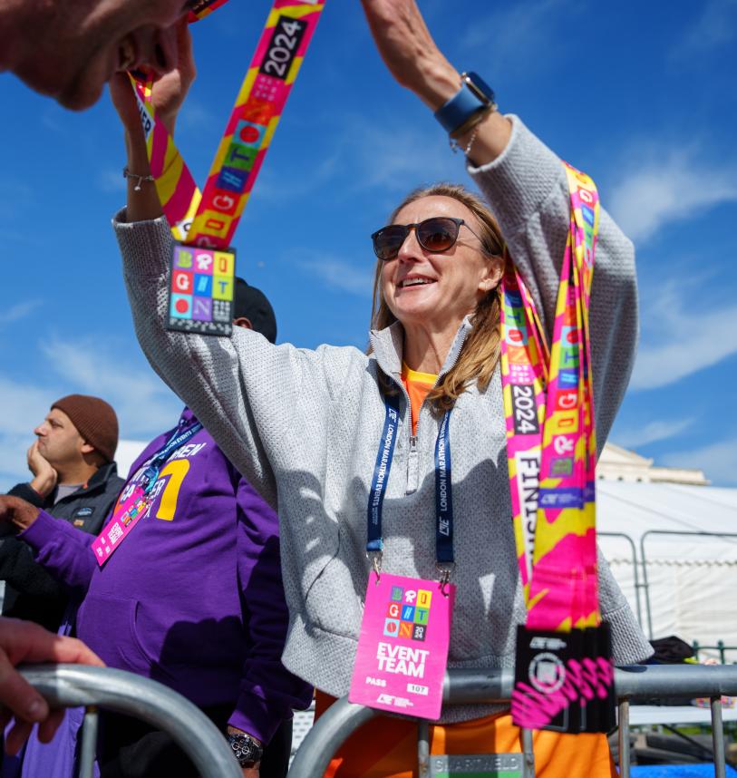 Woman hands medal to participant at the Brighton marathon