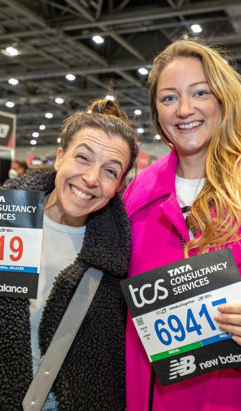 Runners pose for a photo with their bib numbers at the TCS London Marathon Running Show