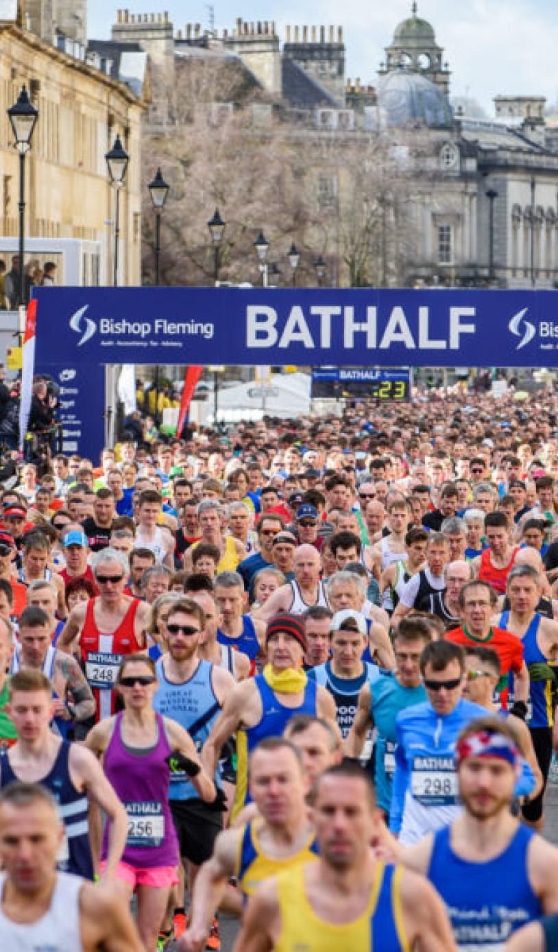 Loads of people in colourful sportswear running through Bath.